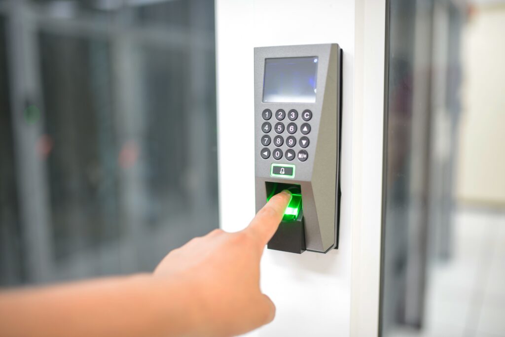 commercial-plumbing A person uses a fingerprint scanner for secure entry in a business setting.